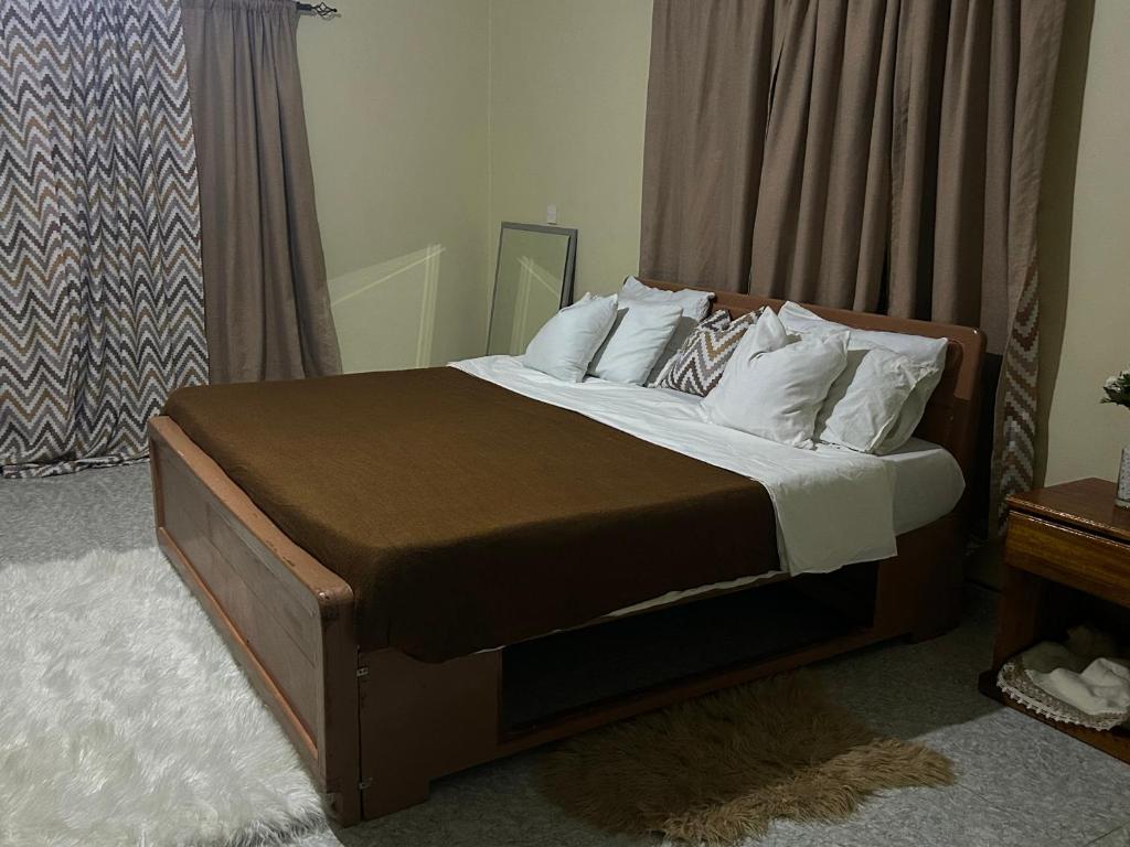 a bedroom with a large bed with white pillows at MableHomestay in Mzuzu