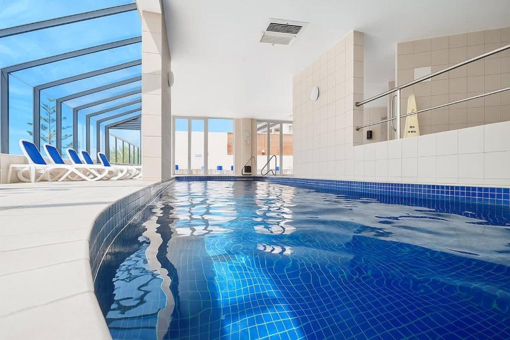 Una piscina con azulejos azules en un edificio. en 1BR Apartment Heated pool, en Gold Coast