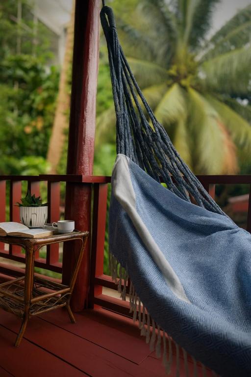 a hammock on a porch with a table and a chair at Happy Elephant Bungalows in Koh Rong Island