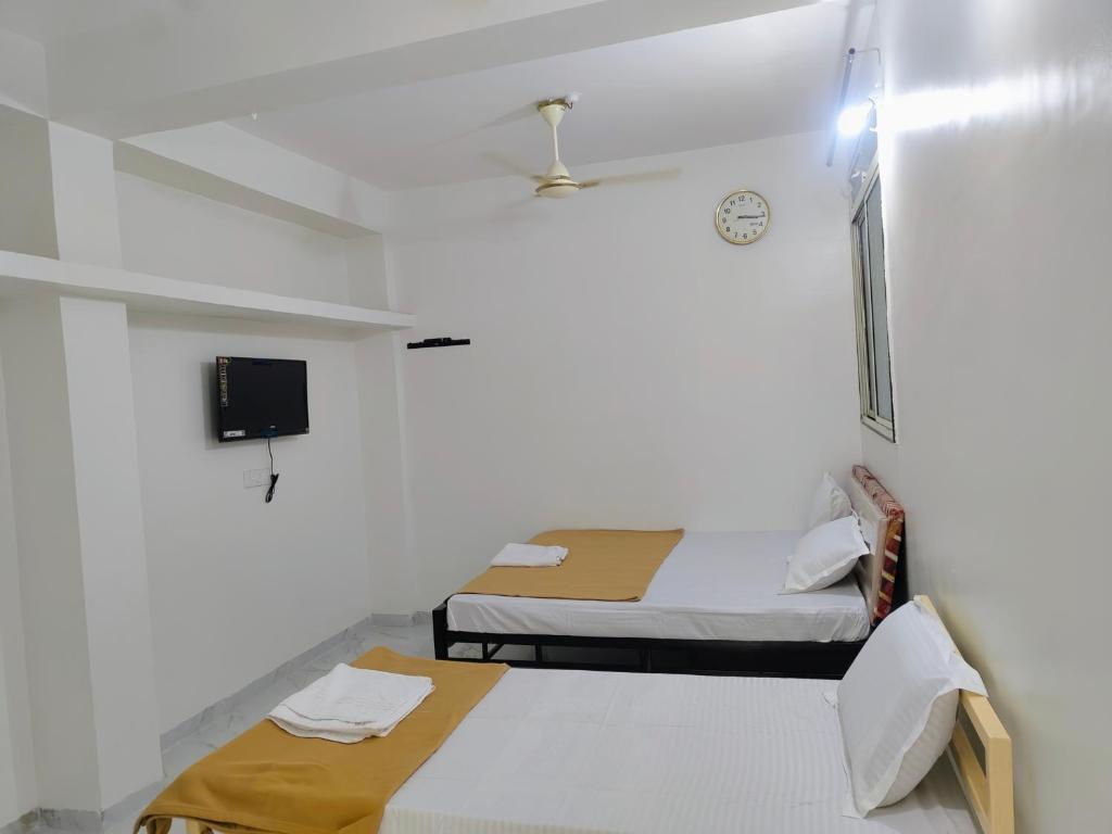 Habitación hospitalaria con 2 camas y TV en Hotel Amardeep Residency, en Aurangabad