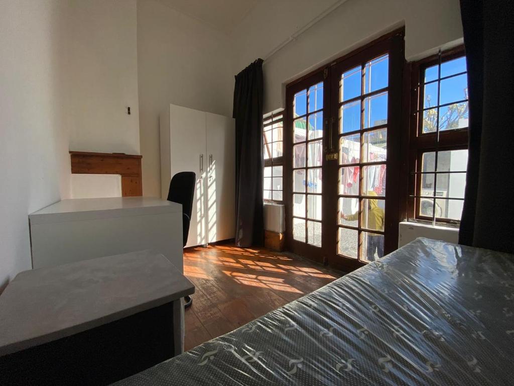 a bedroom with large windows and a bed in a room at House Grace in Gqeberha