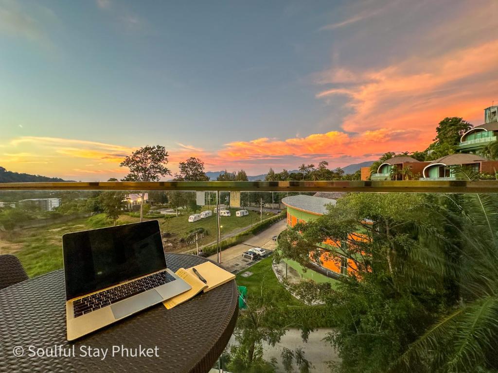 a laptop sitting on top of a table on a balcony at Mountain View Apartment Patong Soulful Stay Romantic Retreat in Patong Beach