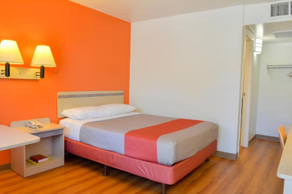 a bedroom with a bed with an orange wall at Motel 6-Santa Nella, CA - Los Banos - Interstate 5 in Santa Nella