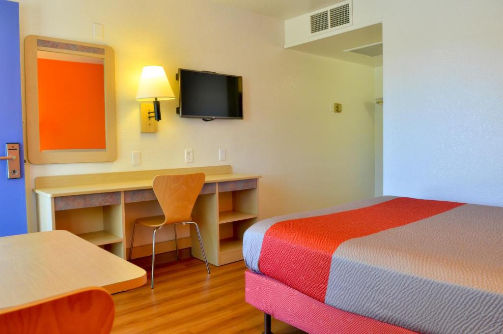 a hotel room with a bed and a desk with a television at Motel 6-Santa Nella, CA - Los Banos - Interstate 5 in Santa Nella