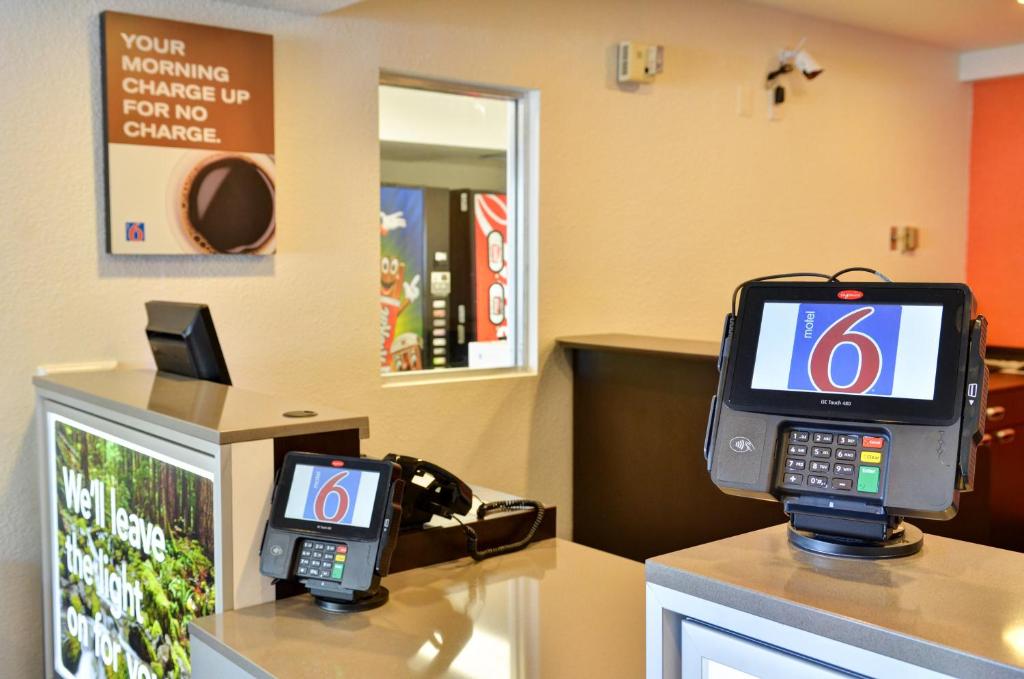 a room with a cell phone and a pay phone at Motel 6-Santa Nella, CA - Los Banos - Interstate 5 in Santa Nella