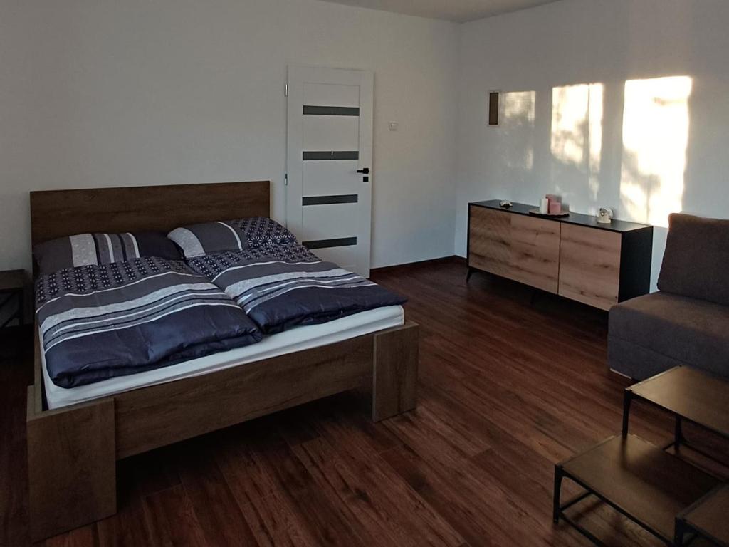 a bedroom with a bed and a couch and a chair at Apartmán pri Gaderskej bráne in Blatnica
