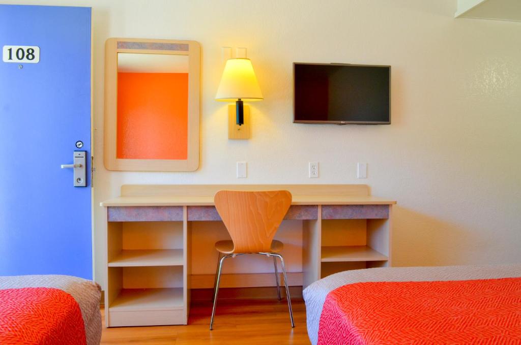 a bedroom with a desk with a mirror and a television at Motel 6-Santa Nella, CA - Los Banos - Interstate 5 in Santa Nella