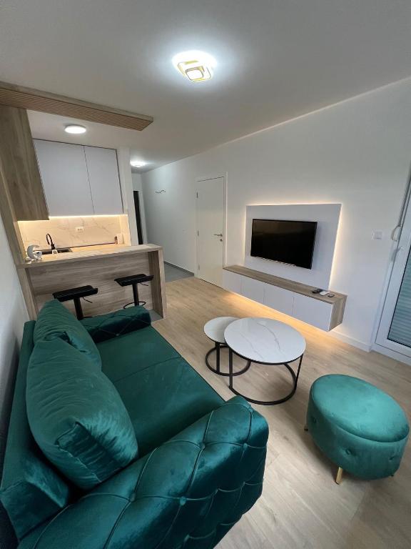 a living room with a green couch and a table at Lux Iva apartman in Doboj