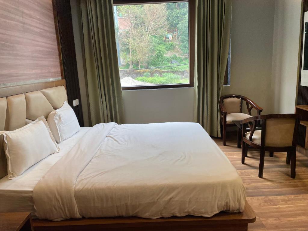 a bedroom with a large bed and a window at Yatram in Rishīkesh