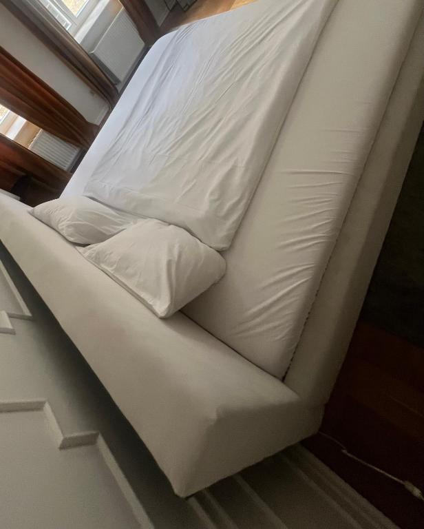 a bed on a boat with white sheets and pillows at Niedras place in Degole