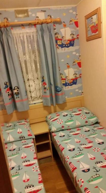 a bedroom with a bed and a window with sailboats on it at The Chase & Grange caravan park ingoldmells ref F in Addlethorpe