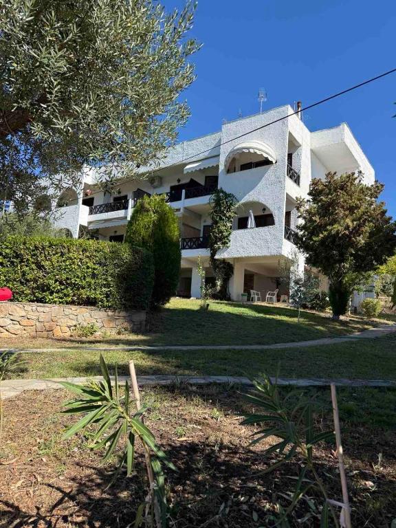a large white building with a yard in front of it at Elia Sea View Apartments 2 in Elia