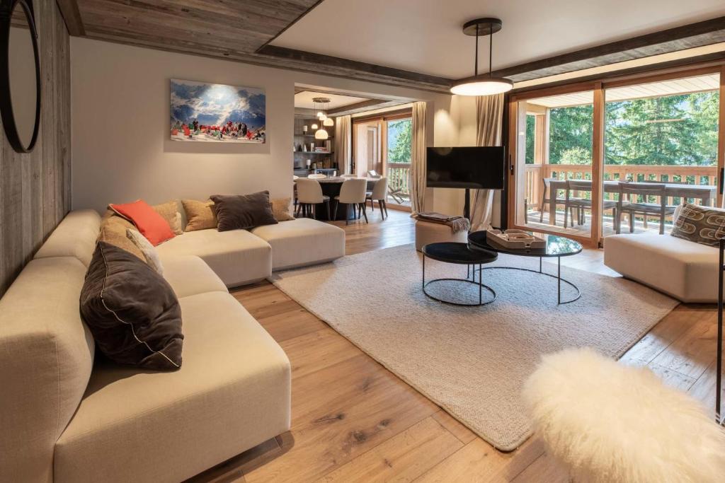 ein Wohnzimmer mit zwei Sofas und einem Fernseher in der Unterkunft Antares Ursa 201 in Méribel