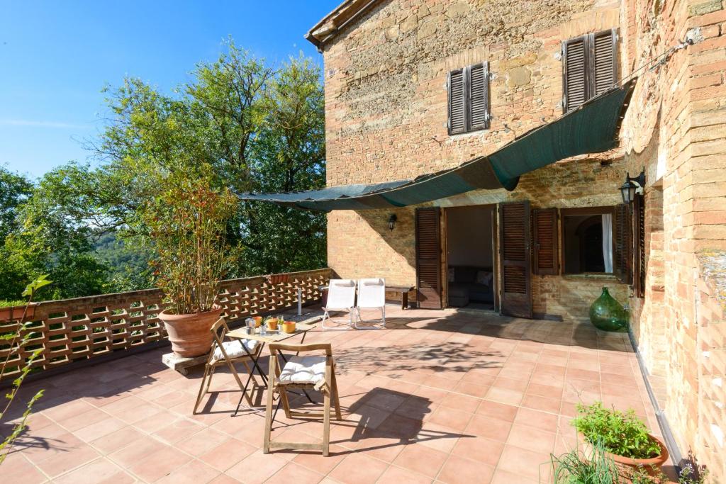 サン・ジョヴァンニ・ダッソにあるAlloggio Val D'orcia con Balcone Panoramico 6' Posti Lettoの建物の前の椅子とテーブルのあるパティオ