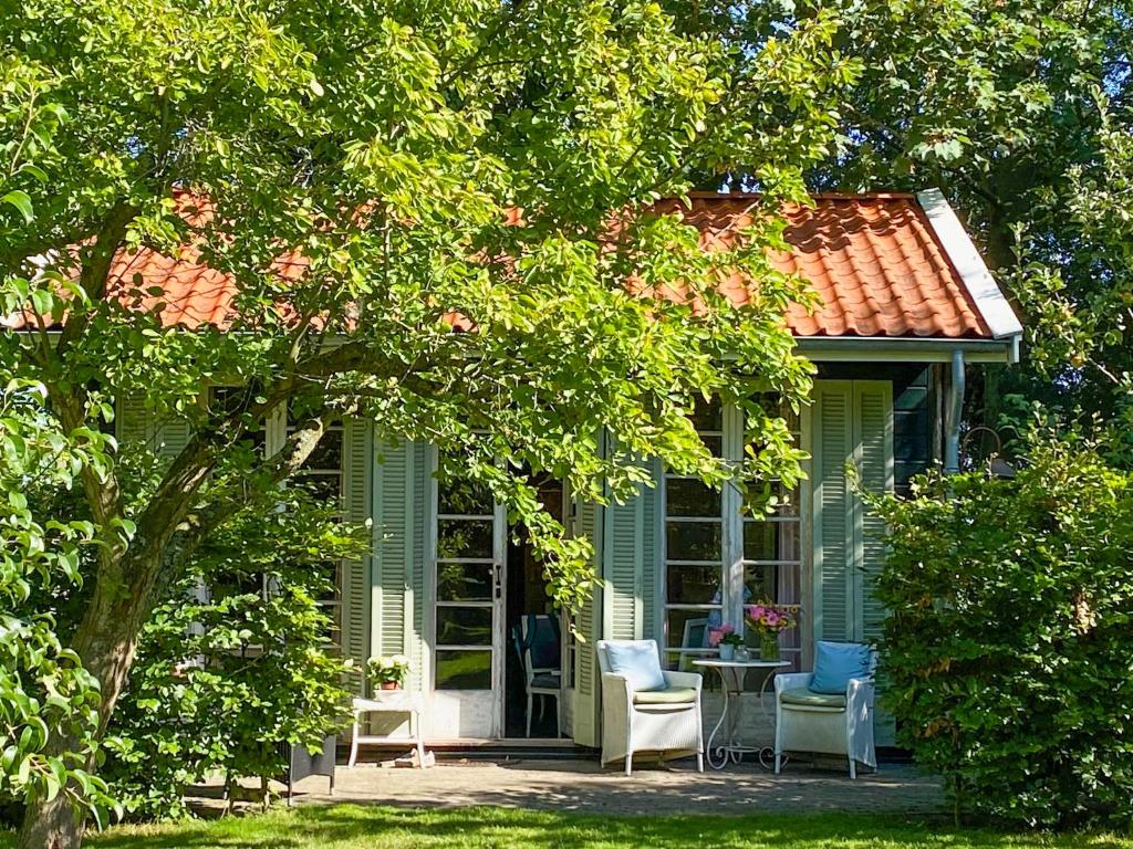 a green house with two chairs and a table at Vakantiehuizen Kats Zeeland De Zwaluwenhof in Kats