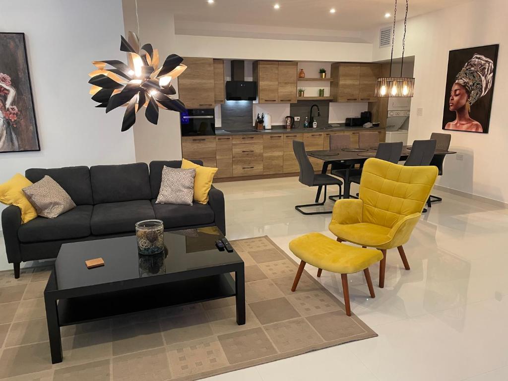 a living room with a couch and chairs and a table at Bubali Modern Suites Aruba in Palm-Eagle Beach