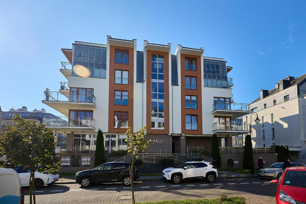 un grande edificio con auto parcheggiate in un parcheggio di Apartment Pegaz & Aqua Marina a Świnoujście