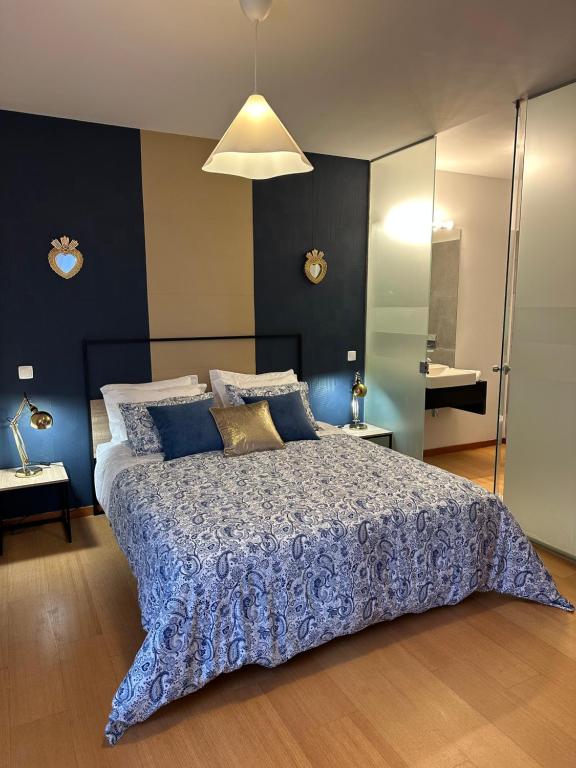 a bedroom with a large bed with blue and white sheets at Burnay Porto Suites in Porto