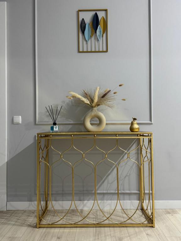 a gold console table in a room with a wall at Apartament modern 2 camere, Parcul Zăvoi in Râmnicu Vâlcea