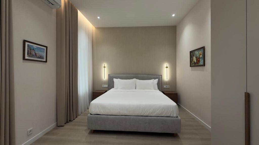 a bedroom with a white bed and a window at MK Luxury Serviced Apartments #3 in Chişinău