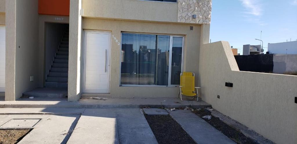 a building with a door and a yellow object next to it at Sol y olas in Playa Unión