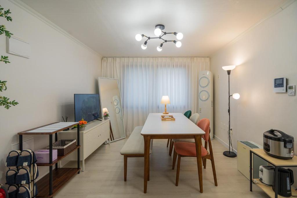 a living room with a table and a dining room at Cozy Haven in Suwŏn-yŏk