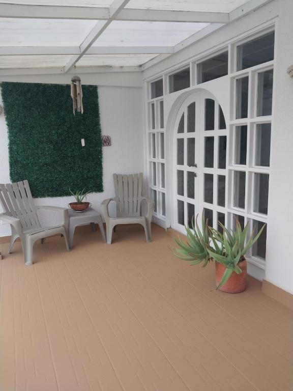 a patio with two chairs and a green wall at Bahía Fragata 204 in San Andrés