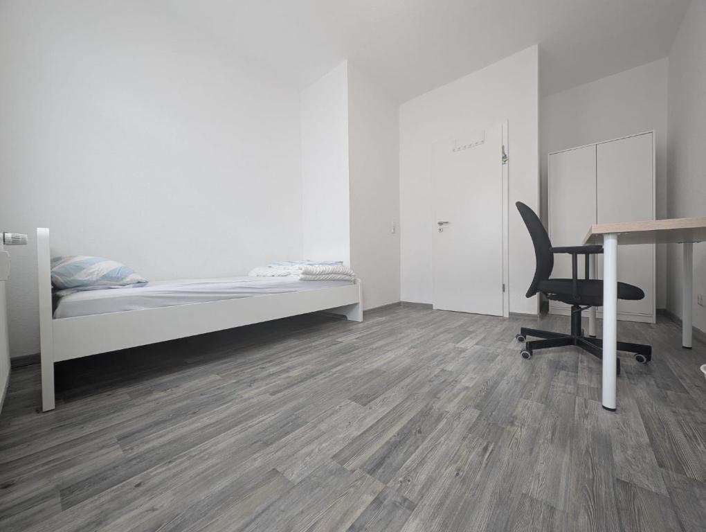 a bedroom with a bed and a desk and a chair at Ihr Premium-Zuhause auf Zeit Komfortabel Wohnen in Bestlage in Hannover