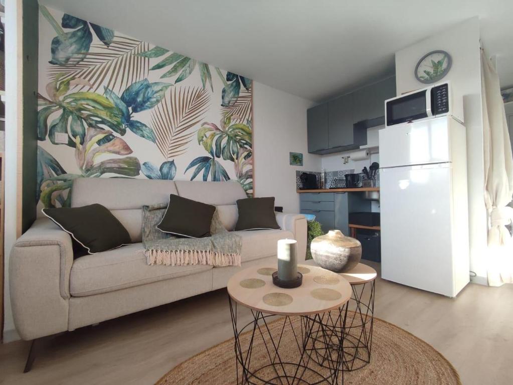 a living room with a couch and a table and a kitchen at STUDIO à SAINT-DENIS DE LA REUNION in Saint-Denis