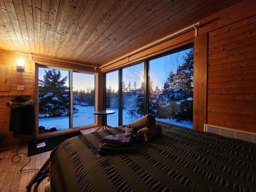a bedroom with a large bed and a large window at Chalet Beausite in Saint-Philémon