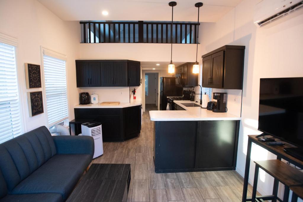 a kitchen with black cabinets and a blue couch at Tiny Blue at Yosemite Gateway in Groveland