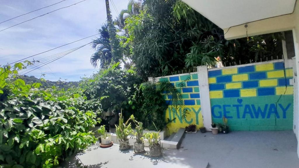 a building with a bunch of plants next to a fence at 5 mins walk from Kingstown! - McKies Hill Suite #1 - Your Home Away from Home in Kingstown