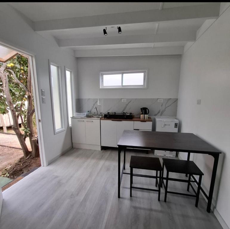 Casa Árbol lodge في بابودو: مطبخ مع طاولة و كرسيين في الغرفة