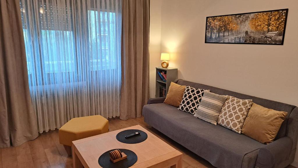 a living room with a couch and a table at Apartman 19 Vinkovci, klimatiziran, self check-in in Vinkovci