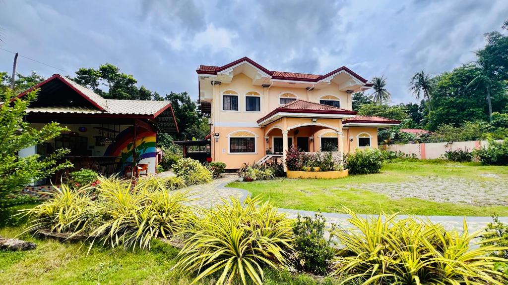 a house with a garden in front of it at Chateau La Princesa rooms with garden, Bar & billiard in Puerto Princesa City