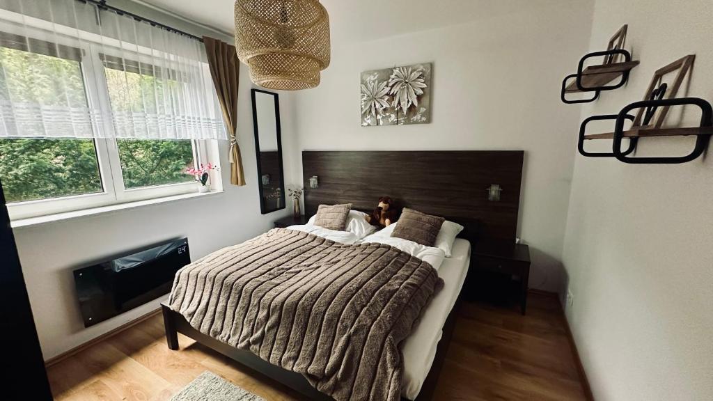 a bedroom with a large bed with a wooden headboard at Donovaly Apartman Galileo in Donovaly