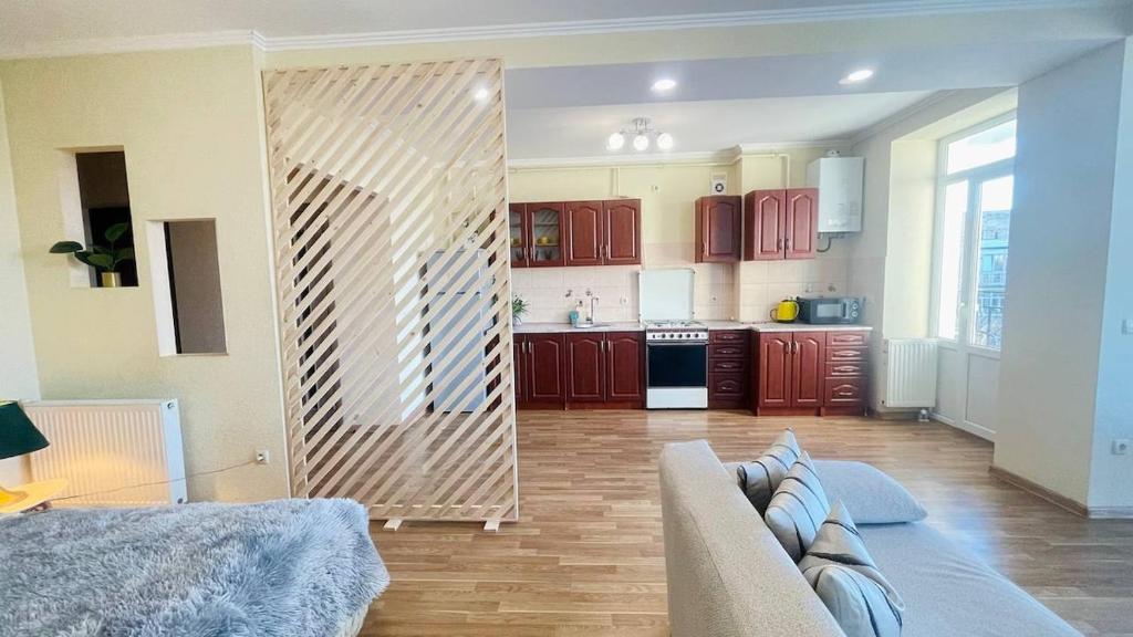 a living room with a couch and a kitchen at Затишна красива студія в новобудові з балконом in Chernivtsi