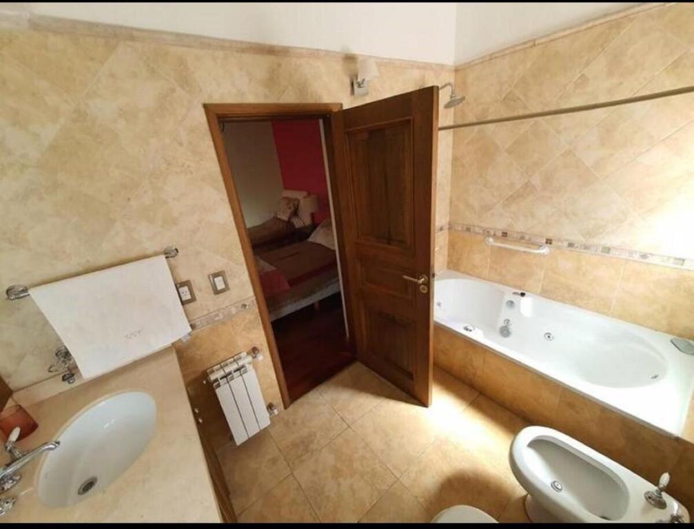 a bathroom with a sink and a tub and a toilet at Tu Casa de Campo - Confort, Hogar & Naturaleza in Estancia Grande