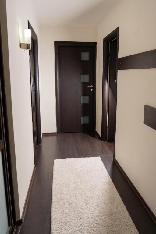 a hallway with a door and a white rug at Casa M&R in Bucharest