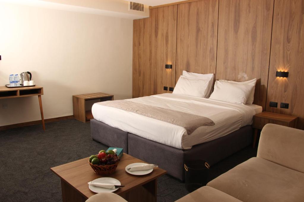 a hotel room with a bed and a couch at Sandy Palace Hotel Amman in Amman