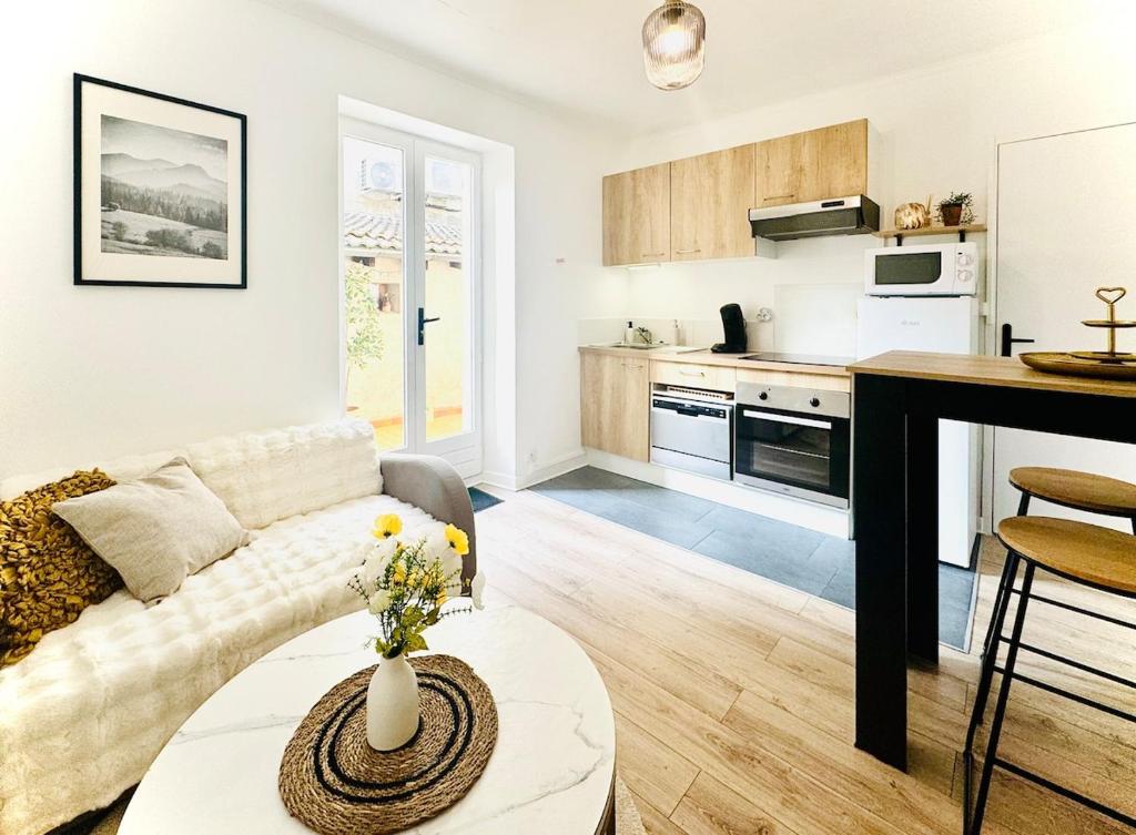 un soggiorno con un divano e un tavolo di L'Écrin d'Or - Élégant & Confortable- Idéalement Situé en Centre-Ville - Terrasse - Gare à 5 min a Valence