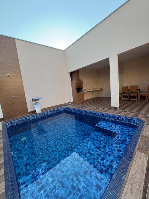 - une grande piscine avec des carreaux bleus dans un bâtiment dans l'établissement Casa Recanto da Paz Premium 2025, à Gurupi