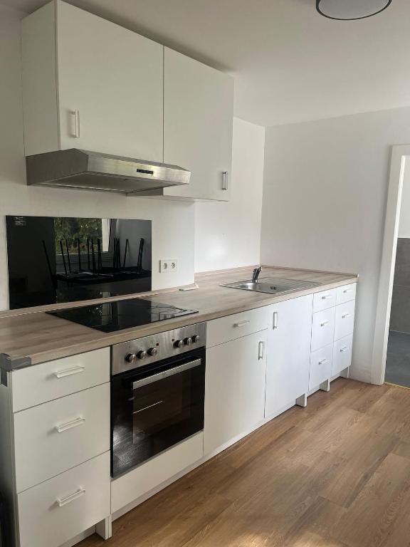 a kitchen with white cabinets and a stove top oven at Heusenstamm Home & Work in Heusenstamm