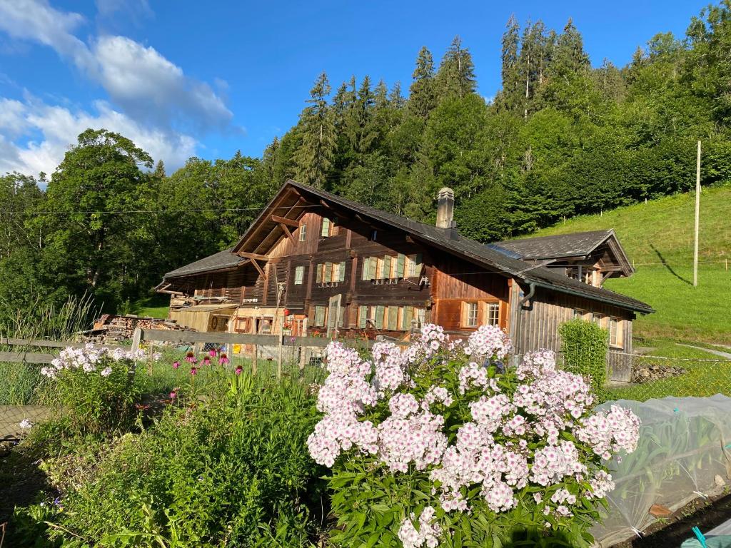 ein Holzhaus mit Blumen davor in der Unterkunft Ferienhaus Schönenmatte in Zweisimmen