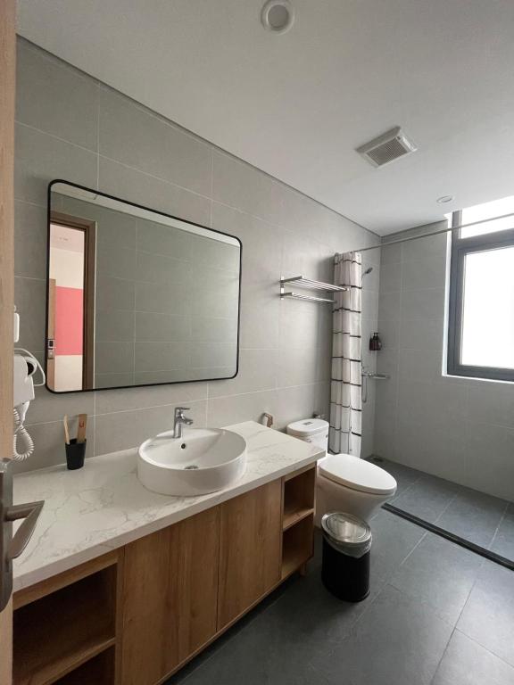 a bathroom with a sink and a toilet and a mirror at Kinh Đô 5 - 20 - 21 in Ðình Loan