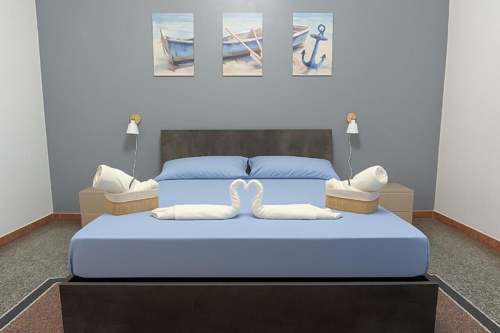 een slaapkamer met een blauw bed met 2 witte kussens bij La Casa Al Mare in Vado Ligure