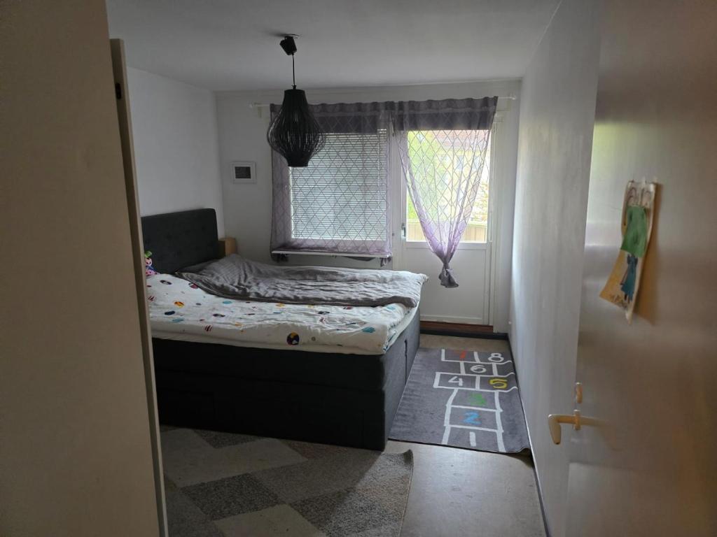 Un dormitorio pequeño con una cama y una ventana. en Aslan Home, en Gotemburgo