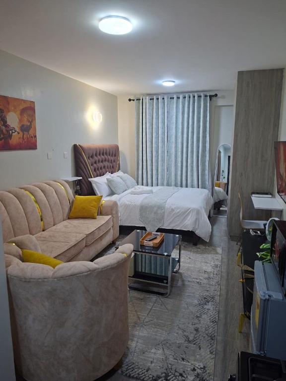 a hotel room with a bed and a couch at Staycation with Ryn in Ruaka