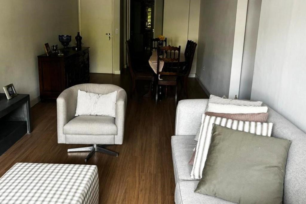 a living room with a couch and a chair at Apartamento Centro Serra Negra in Serra Negra