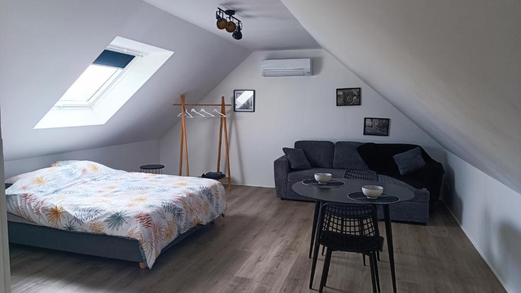 a bedroom with a bed and a table and a couch at Les tournesols in Woincourt